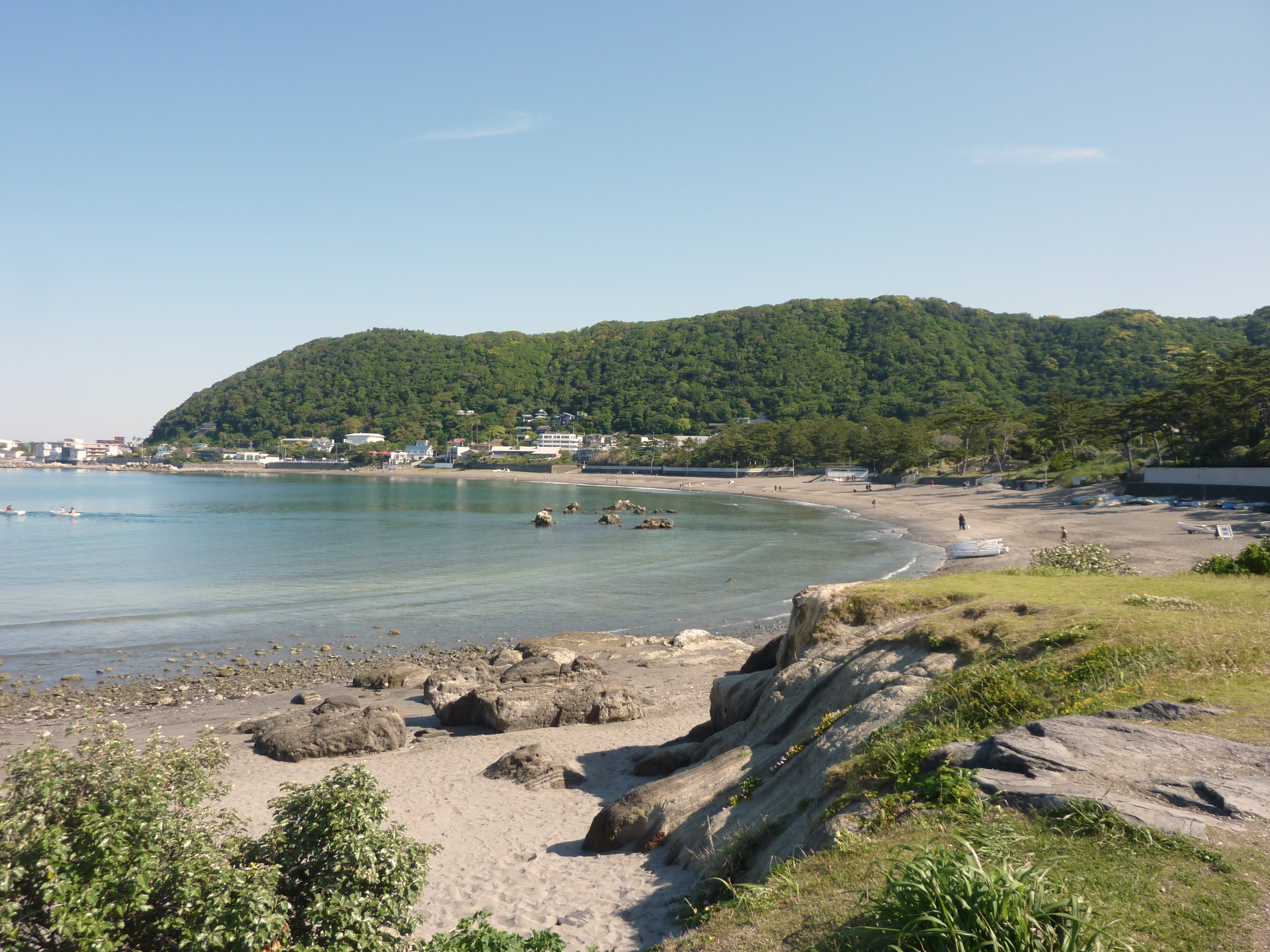 Isshiki Beach in Hayama, with a curved sandy shore and wooded hills